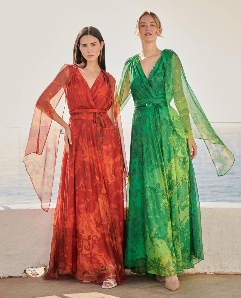 Dos mujeres luciendo vestidos estampados largos verde y rojo de la tienda Estrena Moda de Cartagena
