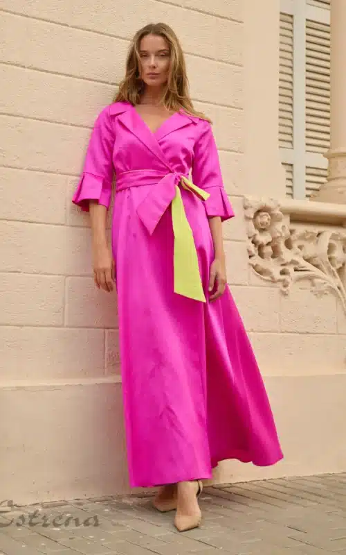 Mujer con vestido camisero largo fucsia satinado y cinturón verde lima para invitada de boda en Cartagena.