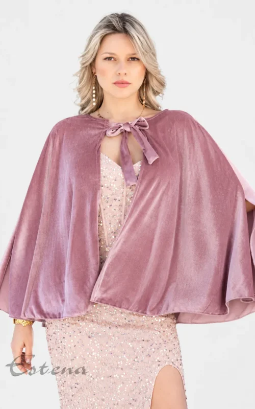 Mujer con capa corta de terciopelo rosa con lazada al cuello sobre un vestido de lentejuelas de Estrena Moda Cartagena.