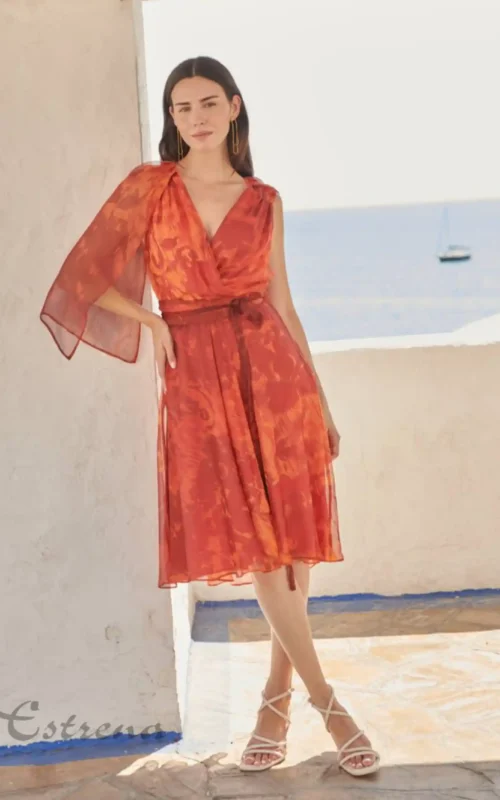 Vestido corto de fiesta color teja con gasa fluida y escote cruzado para invitada de boda en Estrena Moda.