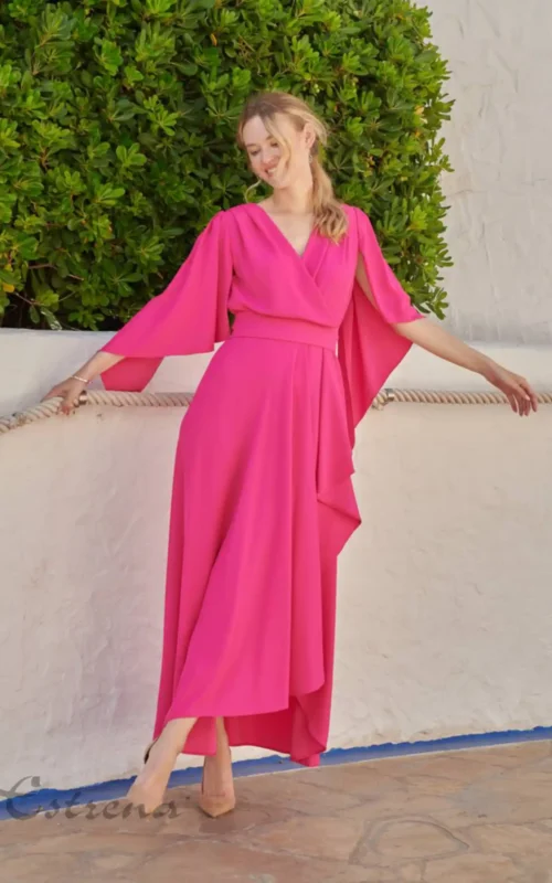 Vestido largo de fiesta color rosa fucsia con escote cruzado y mangas estilo capa para invitada de boda en Cartagena.