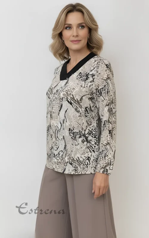 Mujer rubia de perfil luciendo blusa de manga larga con estampado jaspeado gris y cuello en uve negro con apliques.