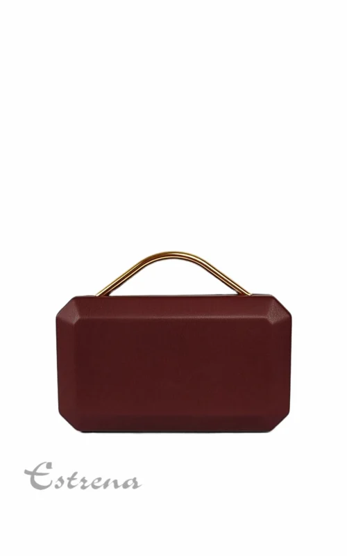 Bolso clutch rígido de fiesta color borgoña con asa metálica dorada sobre un fondo blanco.