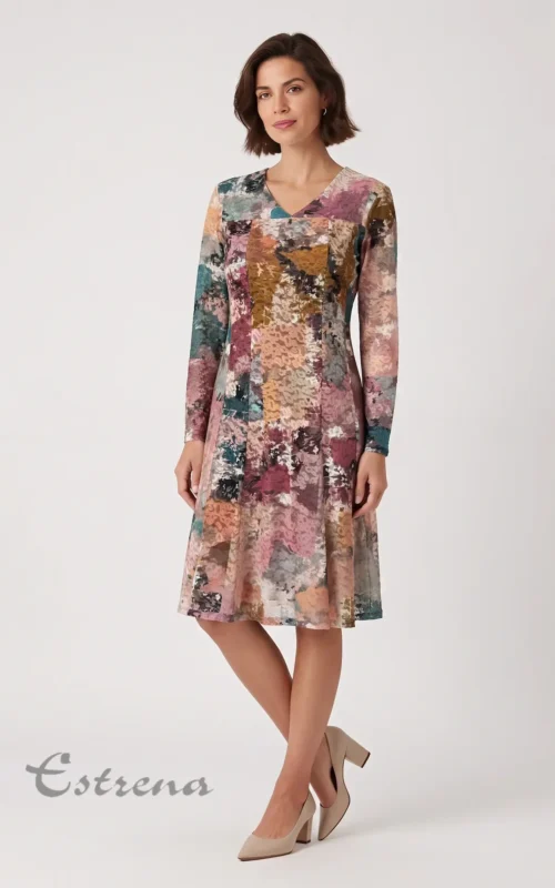 Mujer posando con un vestido midi texturizado de manga larga y estampado abstracto multicolor en tonos rosa, morado y verde.