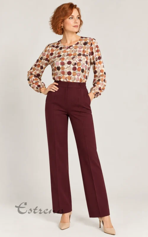 Mujer luciendo blusa con estampado de círculos retro y pantalones anchos granates