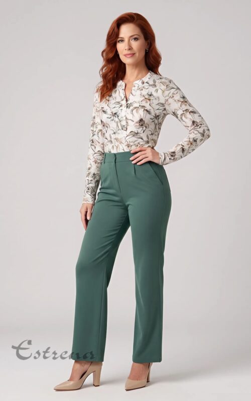 Mujer pelirroja posando con blusa de flores de manga larga blanca combinada con un pantalón de pinzas verde oliva.