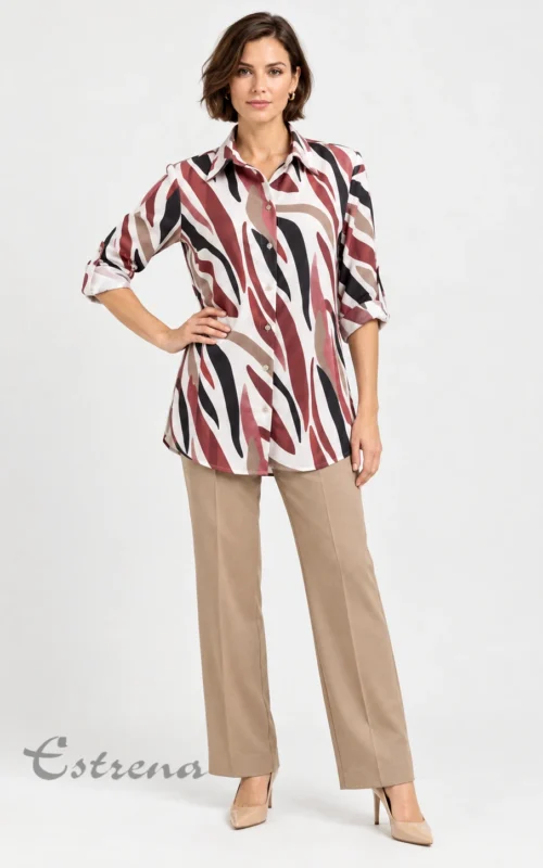 Mujer vistiendo un blusón camisero largo con estampado de rayas abstractas tipo cebra y un pantalón de pinzas beige