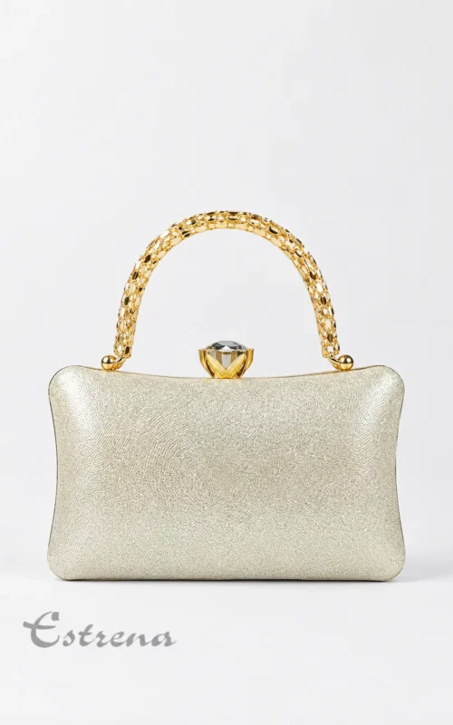 Bolso de fiesta tipo clutch rígido dorado champán con asa labrada y broche tipo cristal sobre fondo blanco.