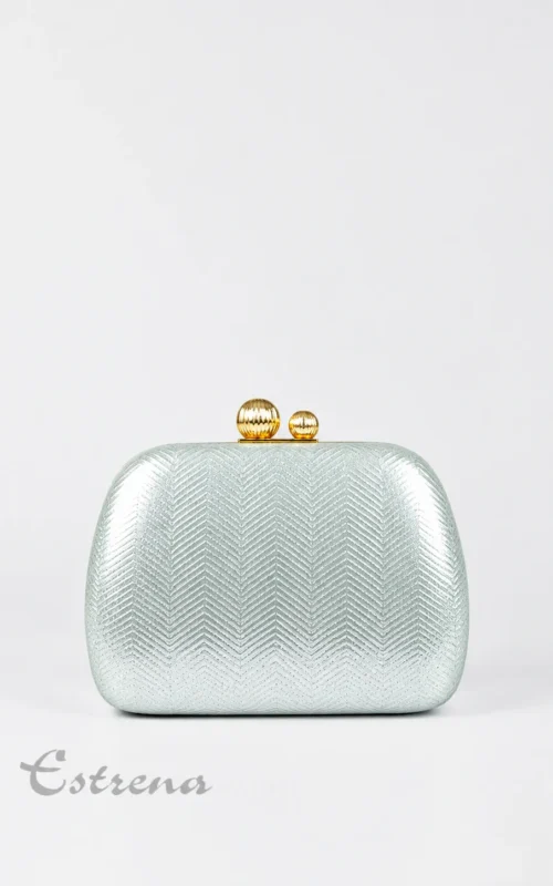 Bolso de mano rígido tipo clutch plateado con textura de espiga y cierre dorado de esferas sobre fondo blanco.