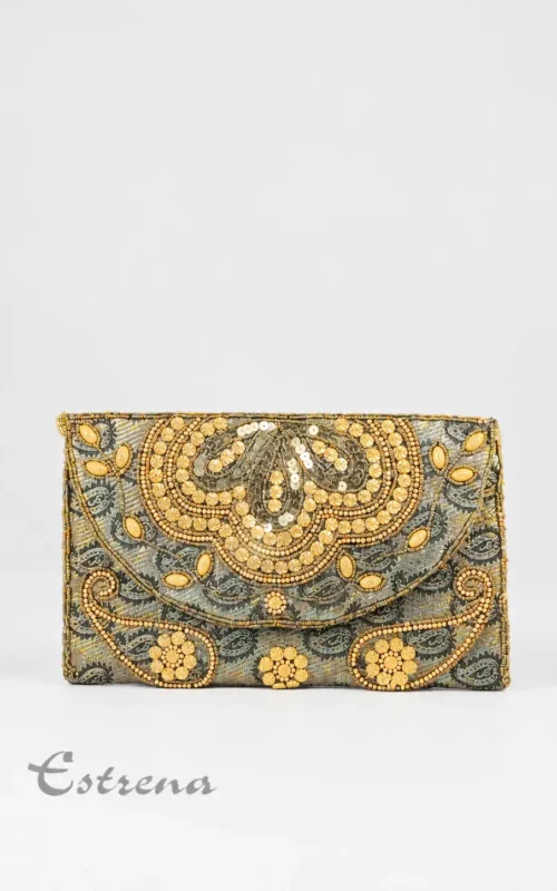 Bolso de fiesta tipo sobre con bordados artesanales y pedrería en color dorado brillante sobre fondo gris texturizado
