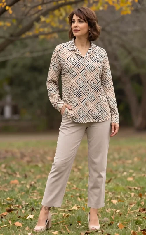 Mujer posando en un parque con una camisa de manga larga con estampado geométrico beige y marrón de Estrena Moda.
