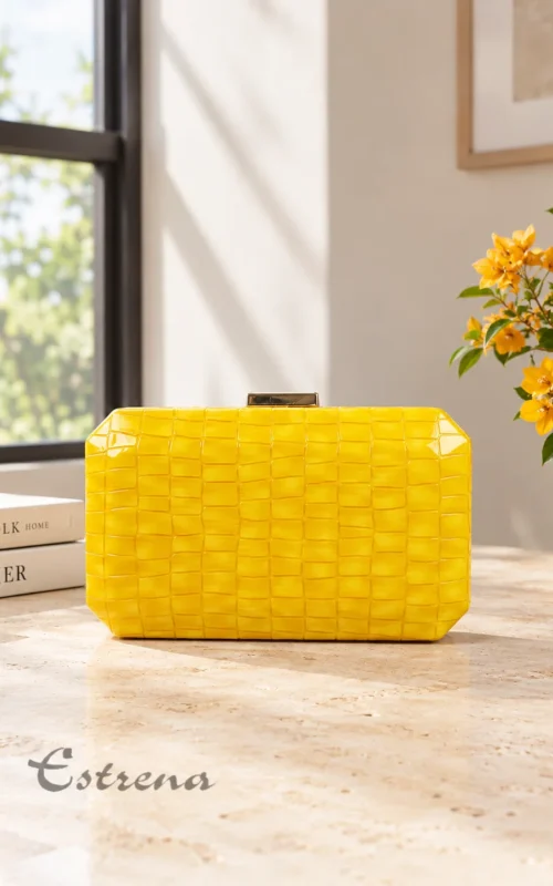 Clutch rígido de fiesta color amarillo brillante con textura trenzada y cierre metálico.
