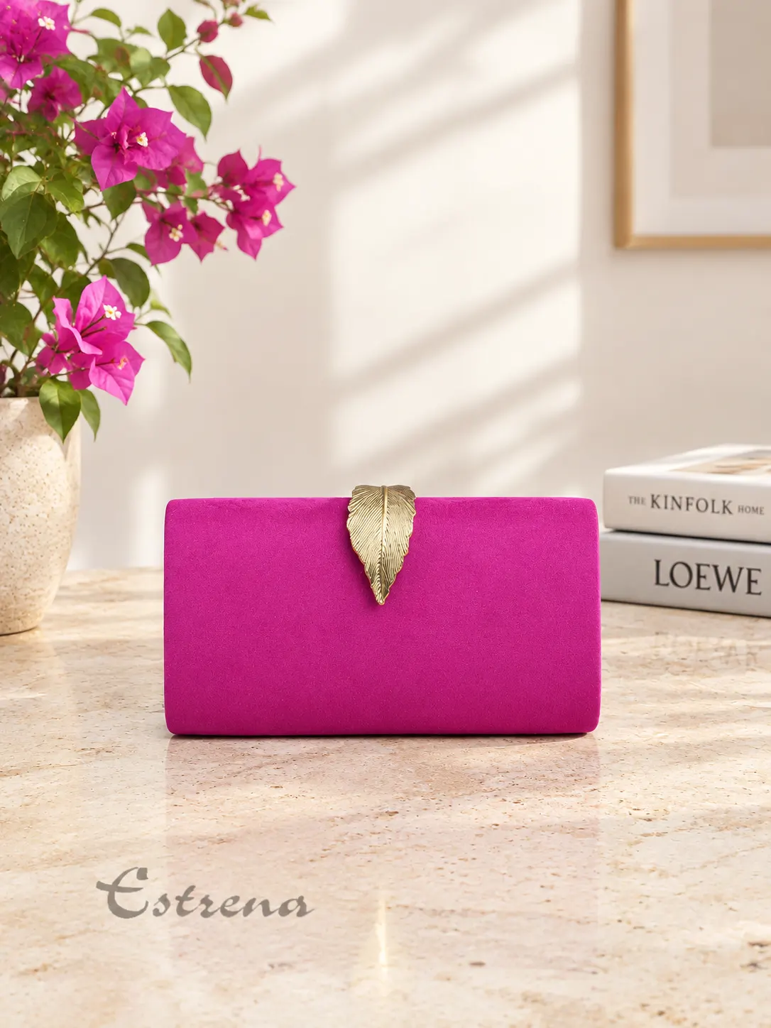 Clutch rígido de fiesta color fucsia en textura suave con cierre en forma de hoja dorada en relieve.