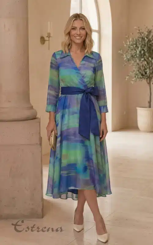 Mujer sonriente con vestido midi de gasa en tonos verdes y azules con cinturón azul de la tienda Estrena Moda.