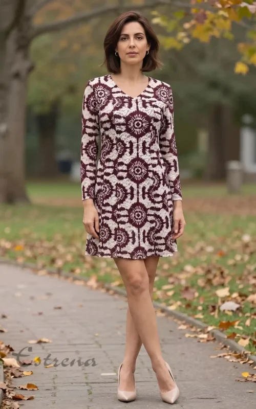Mujer luciendo un vestido corto de manga larga con estampado jacquard granate y beige en un parque de Cartagena.