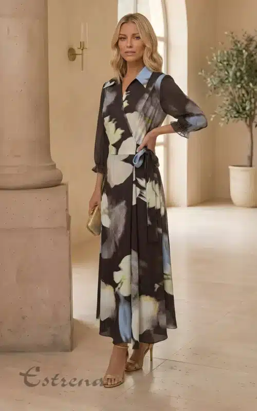 Mujer posando con un elegante vestido cruzado de estampado floral oscuro y azul de la tienda Estrena Moda.