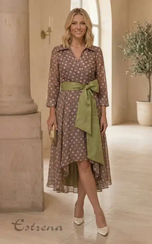 Mujer sonriente vistiendo un vestido midi asimétrico de lunares con fajín verde de la tienda Estrena Moda.